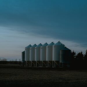 A serene view of farm silos silhouetted against a dusk sky, capturing rural tranquility.